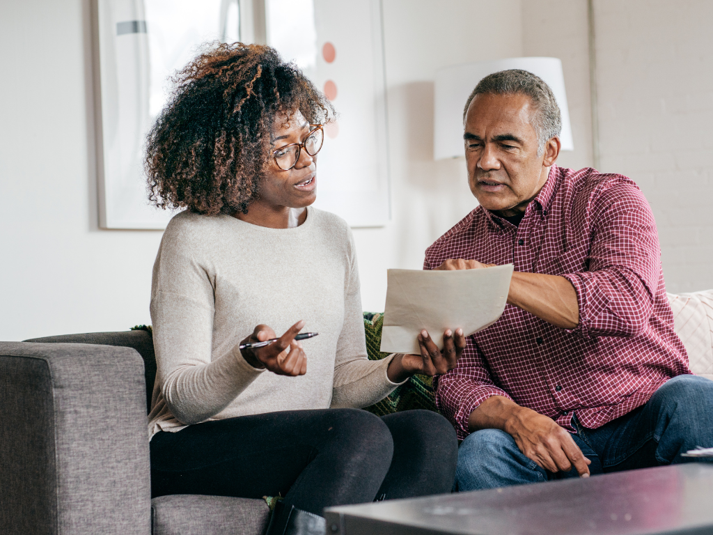 Woman and elder man looking over some papers